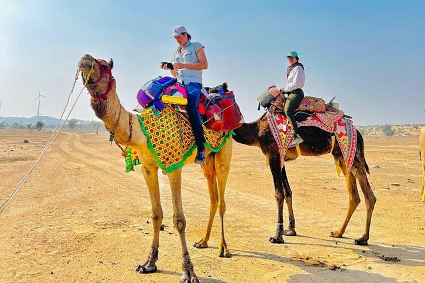Tres camellos con jinetes en un paisaje desértico. 2