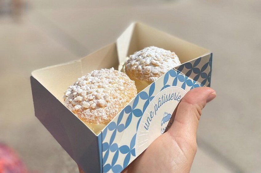 A hand holding a box with two pastries and the text 'une pâtisserie' on it. 3