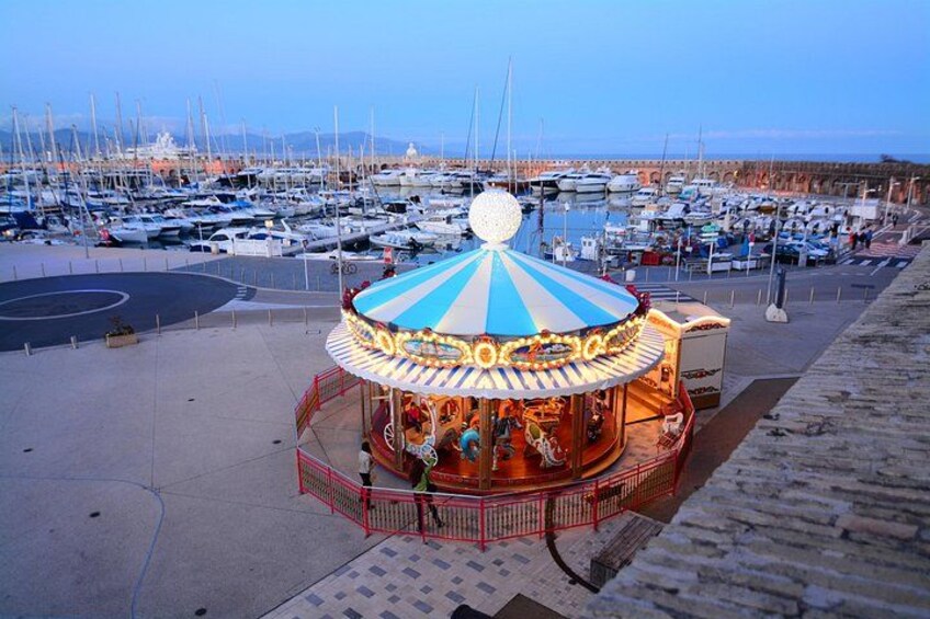 A carousel in a marina with boats in the background. 2