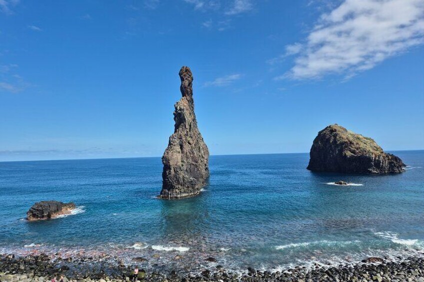 Paesaggio costiero con una formazione rocciosa imponente e una piccola isola nel mare. 4
