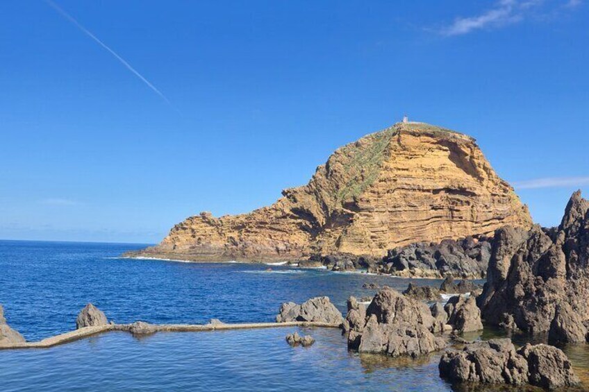 Paesaggio costiero caratterizzato da una scogliera imponente e affioramenti rocciosi. 1