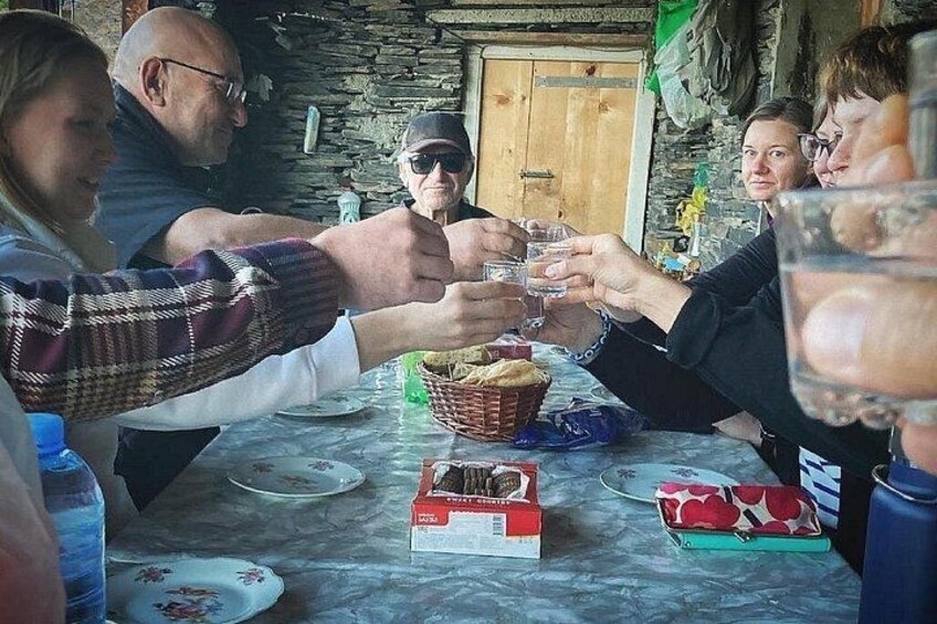 A group of people toasting with glasses at a table with a basket and boxes. 2