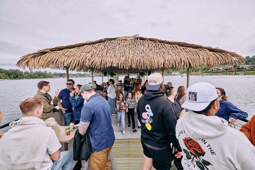A group of people on a boat with a thatched roof structure. 4