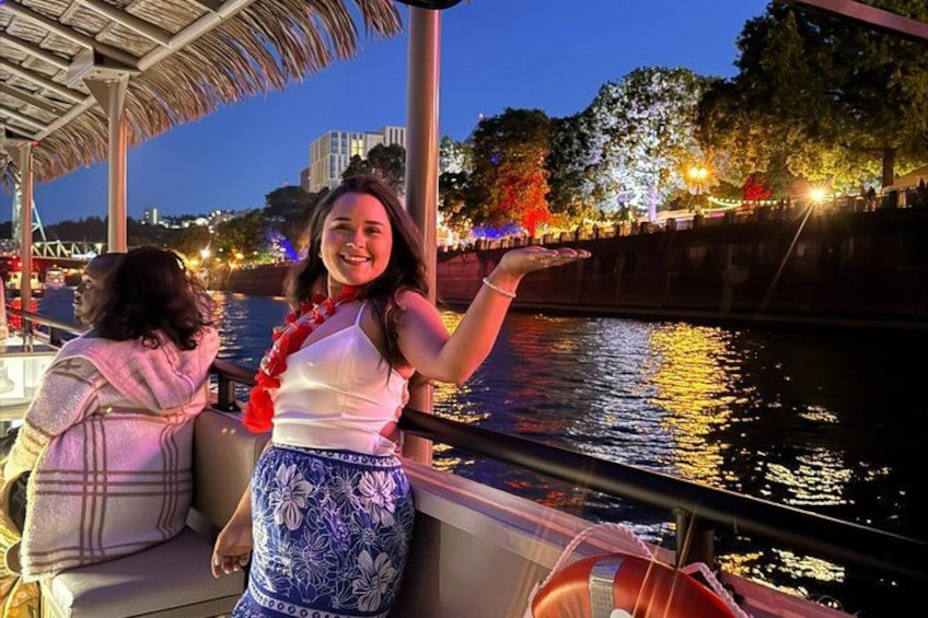 A person on a boat with a cityscape and illuminated trees in the background. 3
