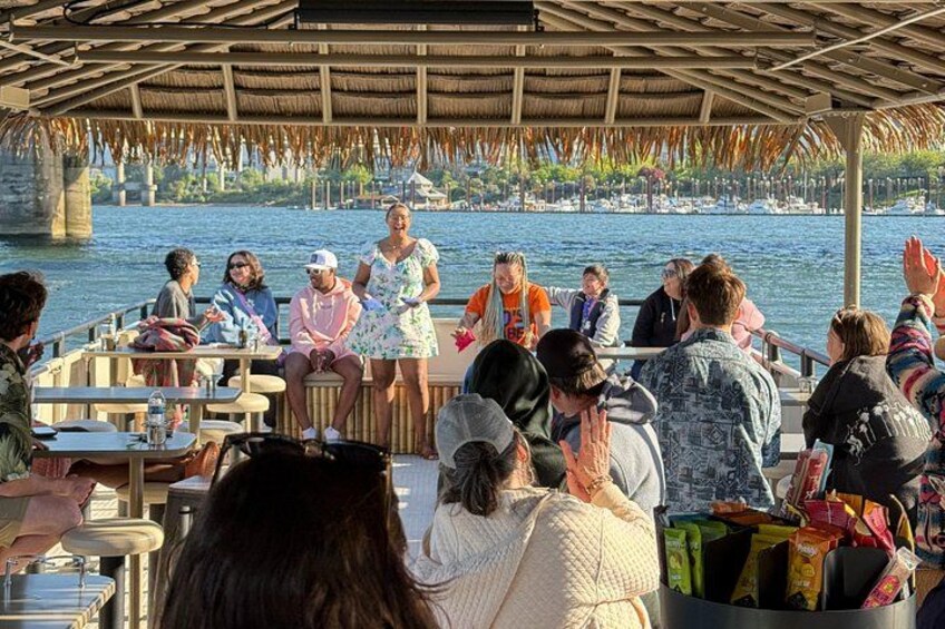 A group of people on a boat with a thatched roof, overlooking a body of water. 2