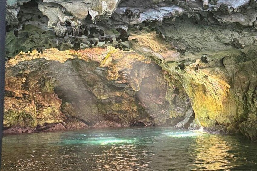 Une grotte où l’eau reflète la lumière, avec des parois rocheuses et une petite cascade. 2