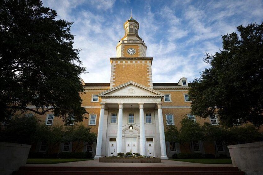 A building with a clock tower, columns, and a clear sky. 2