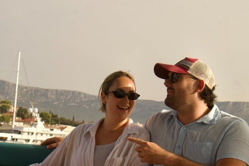 Two people on a boat with a mountainous landscape in the background. 2