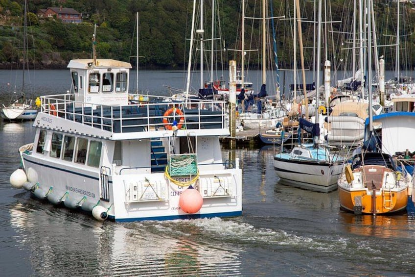 A marina with several boats docked, including a white boat with a cabin and a smaller orange boat. 3