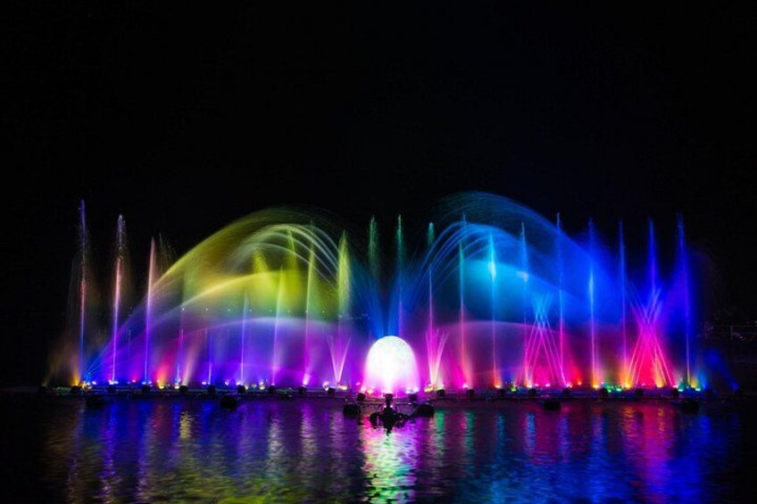 A nighttime water fountain display with colorful lights reflecting on the water. 4