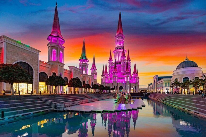 A castle-like building with multiple spires, a large reflective pool, and a dome structure. 2