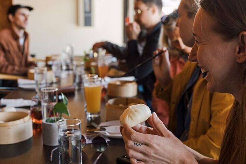 Un grupo de personas sentadas en una mesa con bebidas y comida. 1