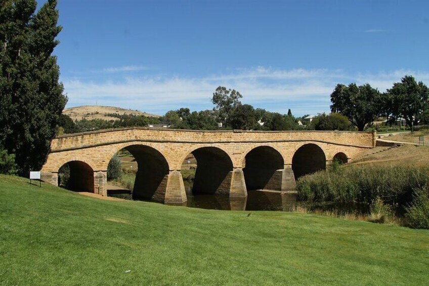 A stone bridge with multiple arches over a body of water. 5