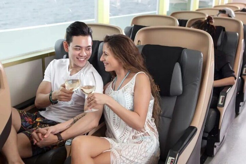 A couple sitting in a cruise ship cabin, holding wine glasses. 3