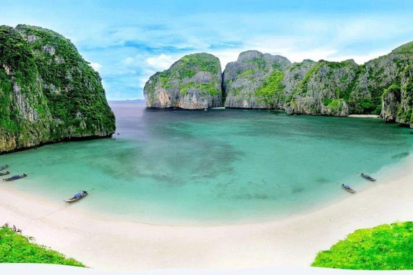 Une plage à l’eau turquoise et limpide, bordée de bateaux et de falaises verdoyantes. 2