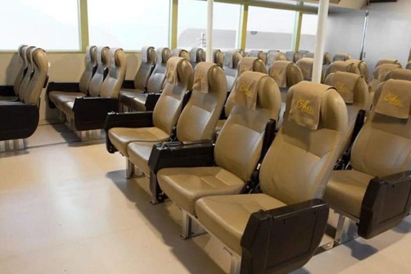 Des rangées de sièges d’avion de couleur beige, dotés d’appuie-têtes et d’accoudoirs, sont disposées à l’intérieur de l’habitacle. 5