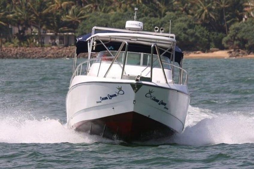 A white boat with 'Ocean Dreams' written on the side, moving through water with a wake behind it. 3