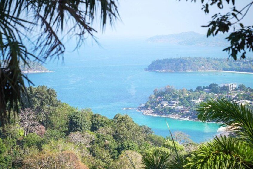 Eine Küstenlandschaft mit freiem Blick auf den Ozean, einer kleinen Insel mit Gebäuden und üppiger Vegetation im Vordergrund. 2