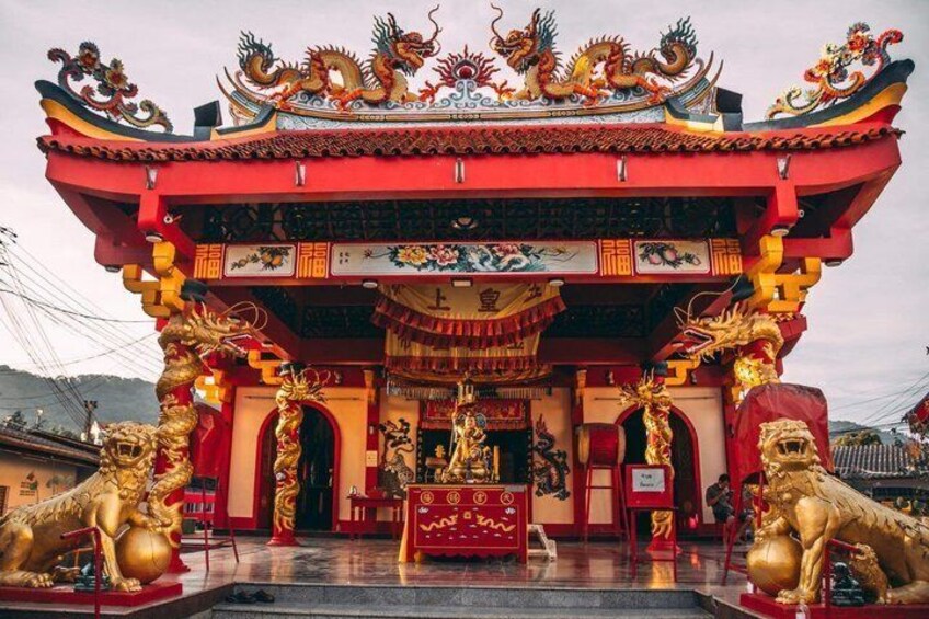 Ein traditioneller chinesischer Tempel mit aufwändiger, rot-goldener Architektur, Löwenstatuen und filigranen Schnitzereien. 4