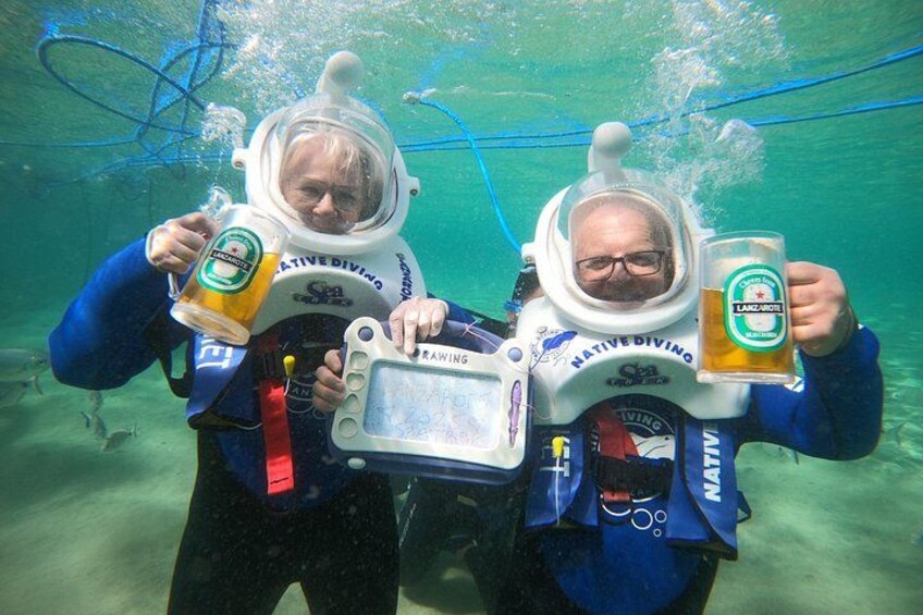 Deux personnes sous l’eau, portant des casques de plongée et tenant des chopes de bière. 4
