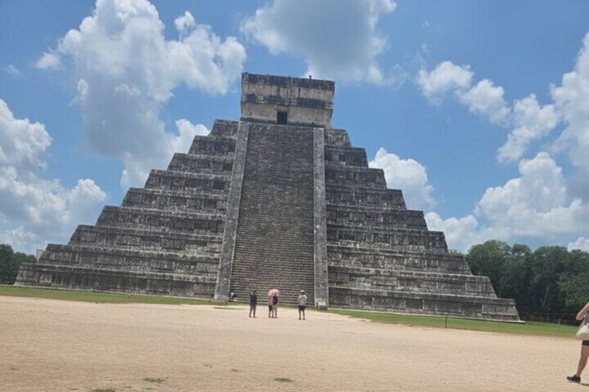En stor pyramidformad byggnad med en platt topp, omgiven av en klar himmel och några moln. 1