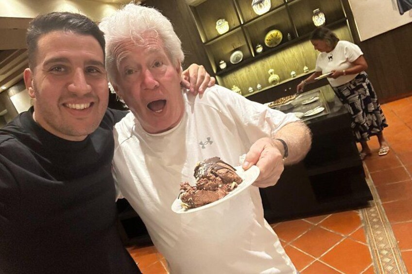 Two people in a restaurant, one holding a plate of food. 3
