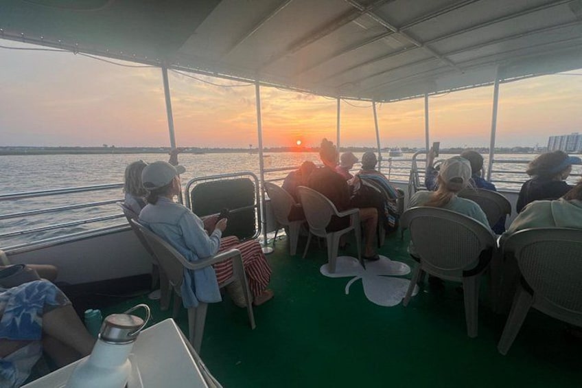 A group of people on a boat during sunset. 2