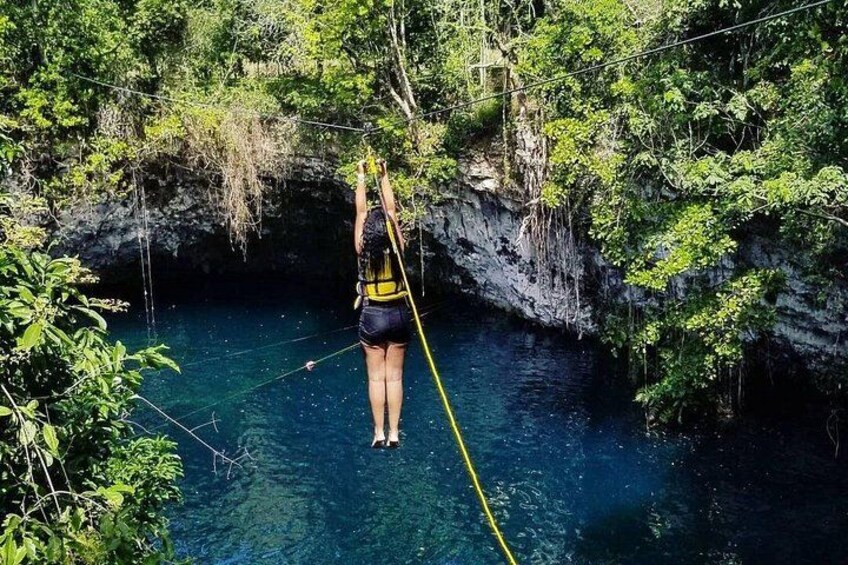 Eine Person macht Bungeesprung von einer Klippe in einen Fluss, umgeben von dichtem Grün. 1