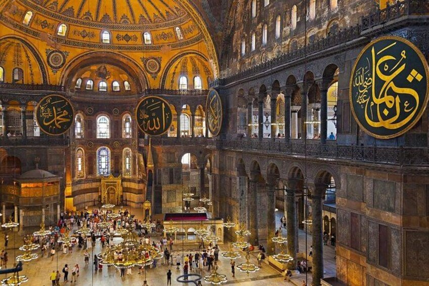 A large, ornate interior with domed ceilings, intricate arches, and large calligraphy. 2