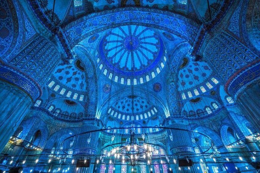 A grand, intricately designed interior with domed ceilings and ornate patterns. 4