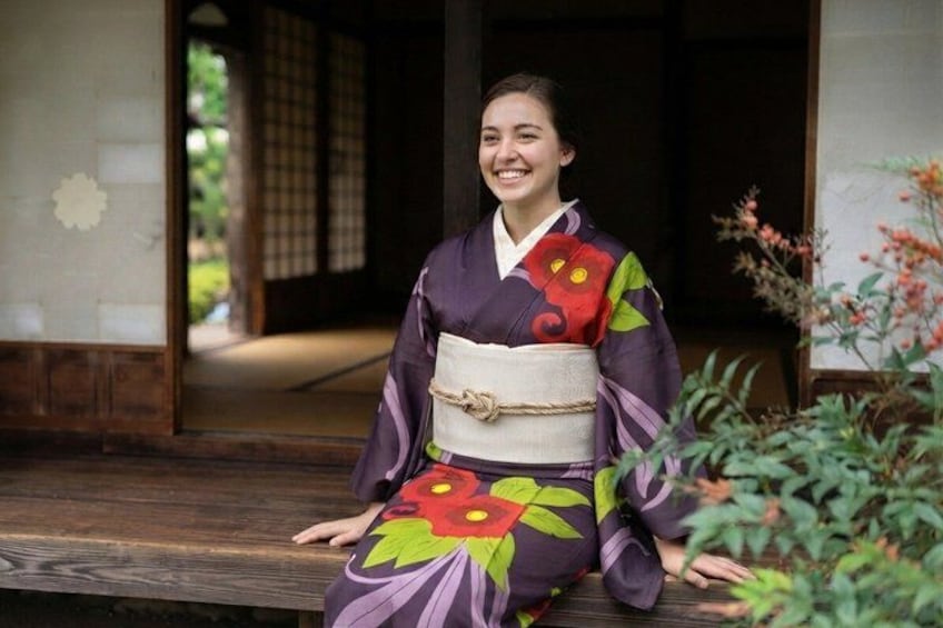 A person in traditional Japanese attire sitting on a wooden bench outdoors. 3