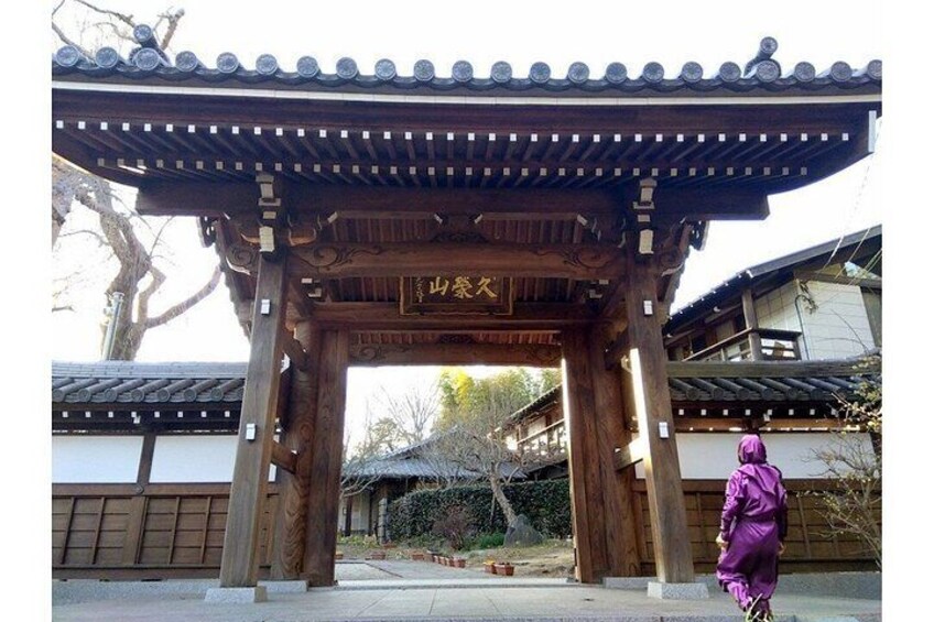 A traditional Japanese gate with wooden pillars and a tiled roof. 4