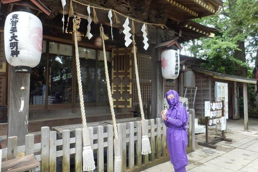 A traditional Japanese building with wooden architecture, a wooden fence, and hanging decorations. 1