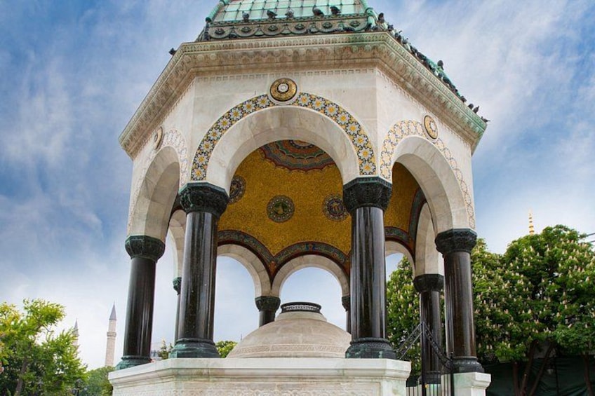A historical building with a tiled dome, arches, and columns. 5