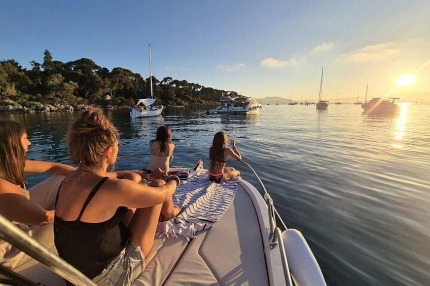 Een groep mensen op een boot, kalm water en een zonsondergang. 2