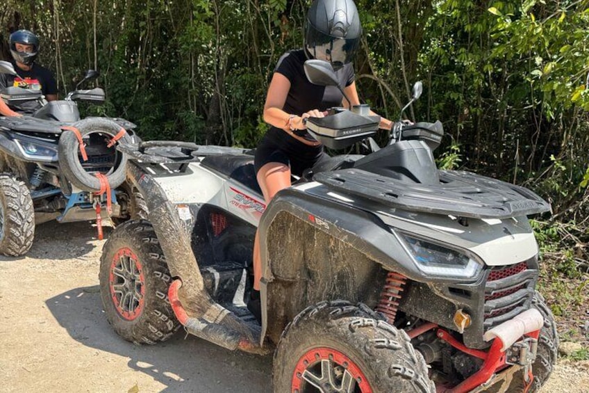 Two off-road vehicles parked on a dirt path surrounded by dense greenery. 2