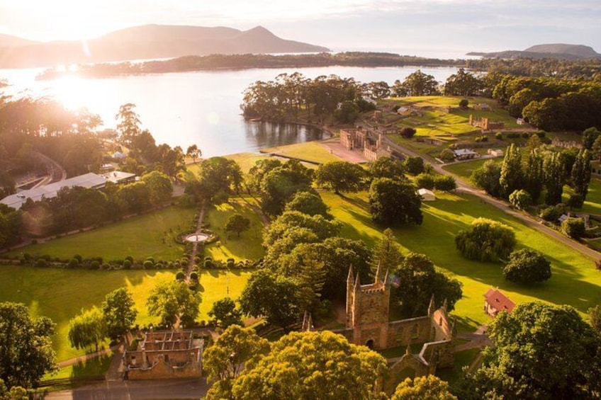 A historic estate with a lake, green lawns, and ruins. 5