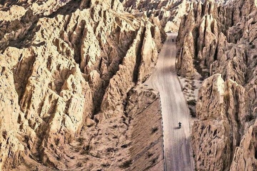 A winding road through a rugged, rocky canyon with steep cliffs on either side. 5