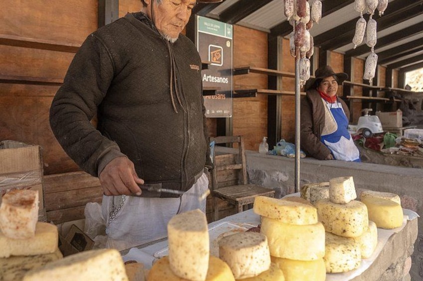 A cheese stand with various types of cheese displayed. 3