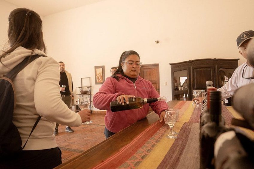 A person pouring wine into a glass at a bar. 4