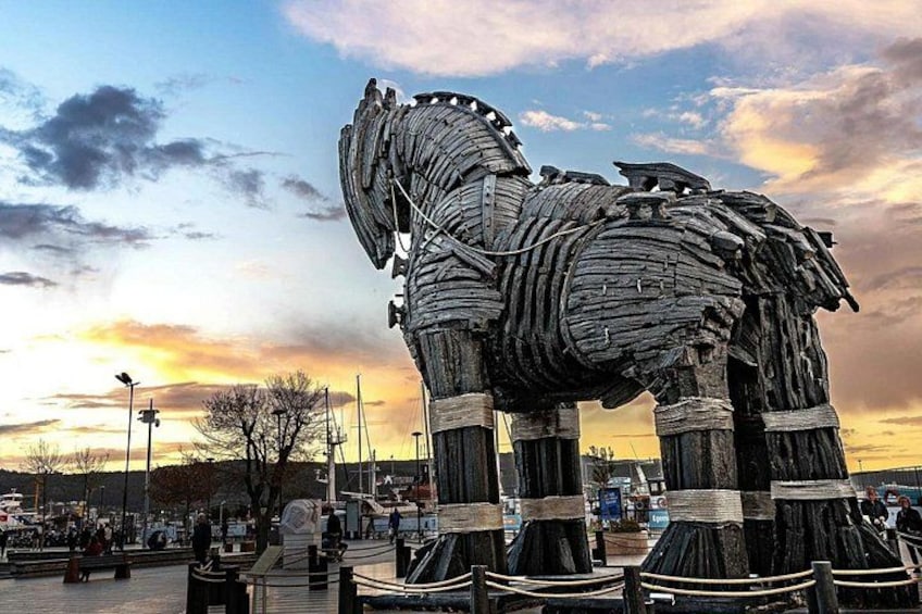 En stor he skulptur i et udendørs miljø med en solnedgang i baggrunden. 1