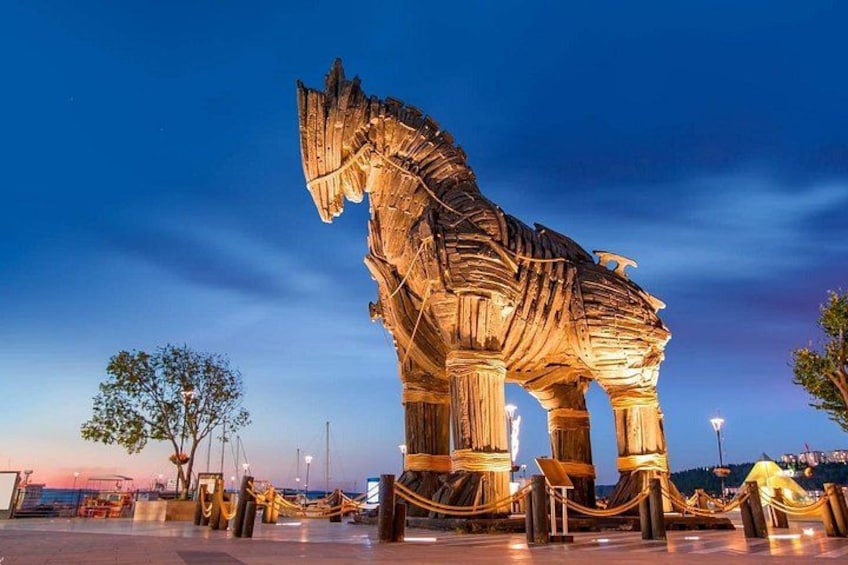 A large illuminated sculpture of a horse in a public square. 2