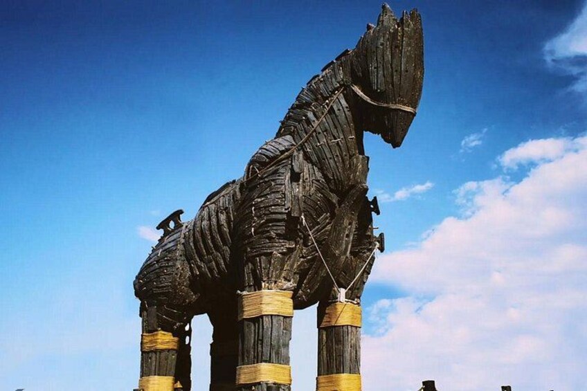 A large, weathered statue of a horse with a rider, standing on a pedestal against a clear sky. 5