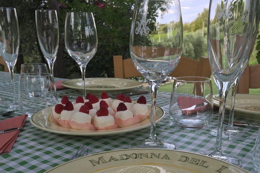 A table with a plate of dessert, wine glasses, and a checkered tablecloth. 3