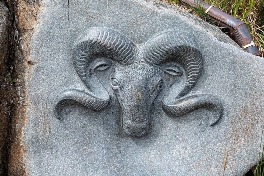A stone carving of a ram's head. 4