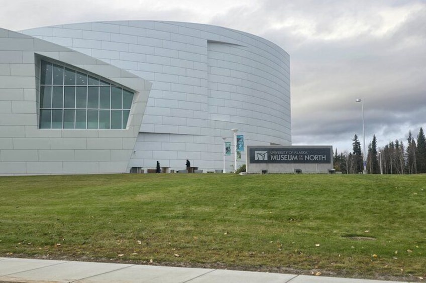 En moderne bygning med en buet facade og et skilt for University of Alaska Museum of the North. 4