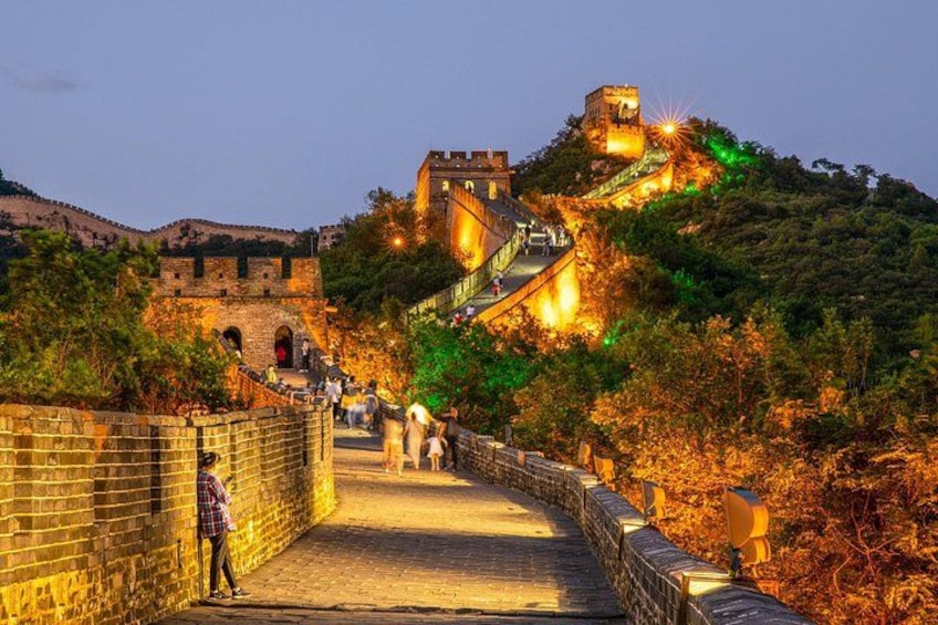The Great Wall of China at sunset with tourists walking along the path. 1