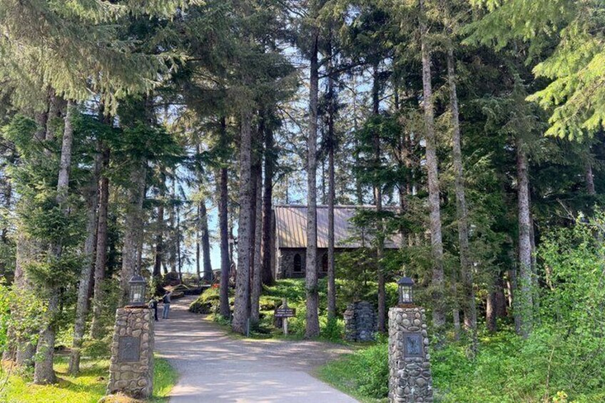 A forested path leading to a rustic building with stone pillars. 4