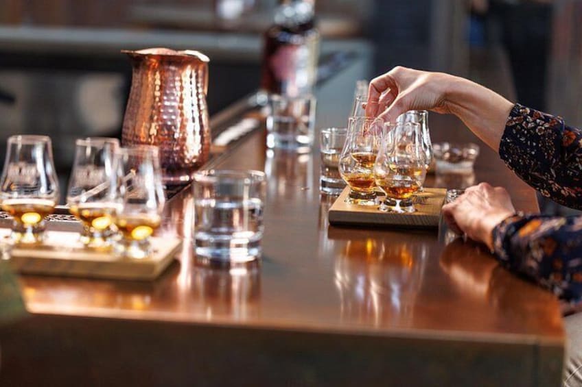 Un bar avec des verres de whisky et un pichet en cuivre. 4