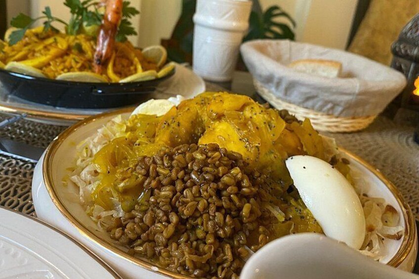 A plate of food with beans, a boiled egg, and a slice of lemon. 4